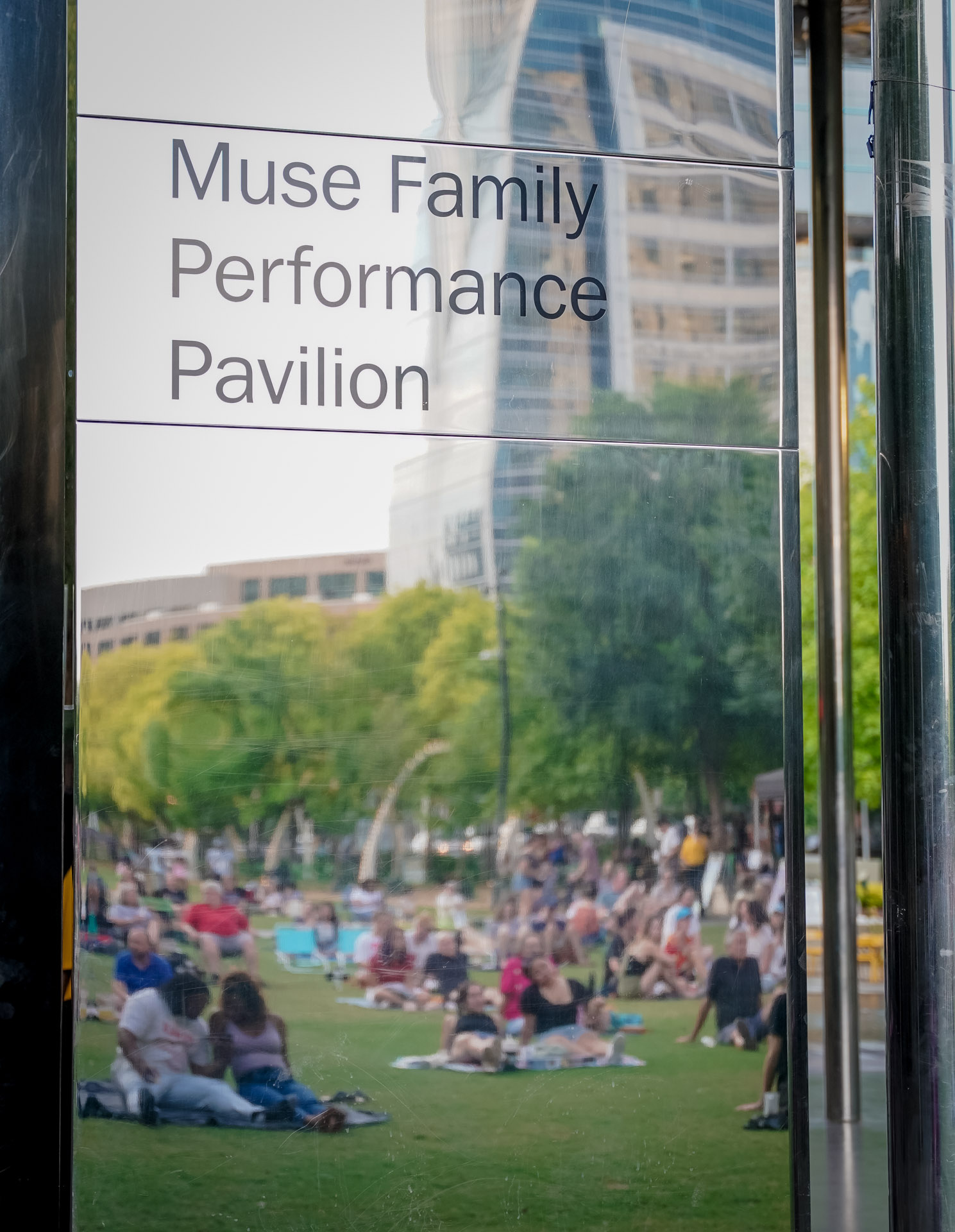 A photo of a mirrored perspective of a crowd sitting on grass