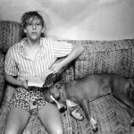 Teresa Taylor is seated on a couch, with a sleeping dog