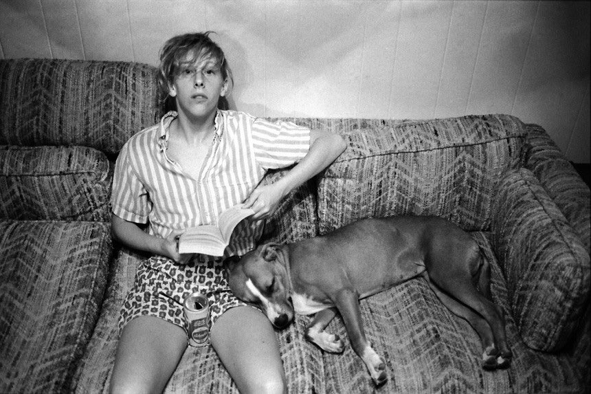 Teresa Taylor is seated on a couch, with a sleeping dog