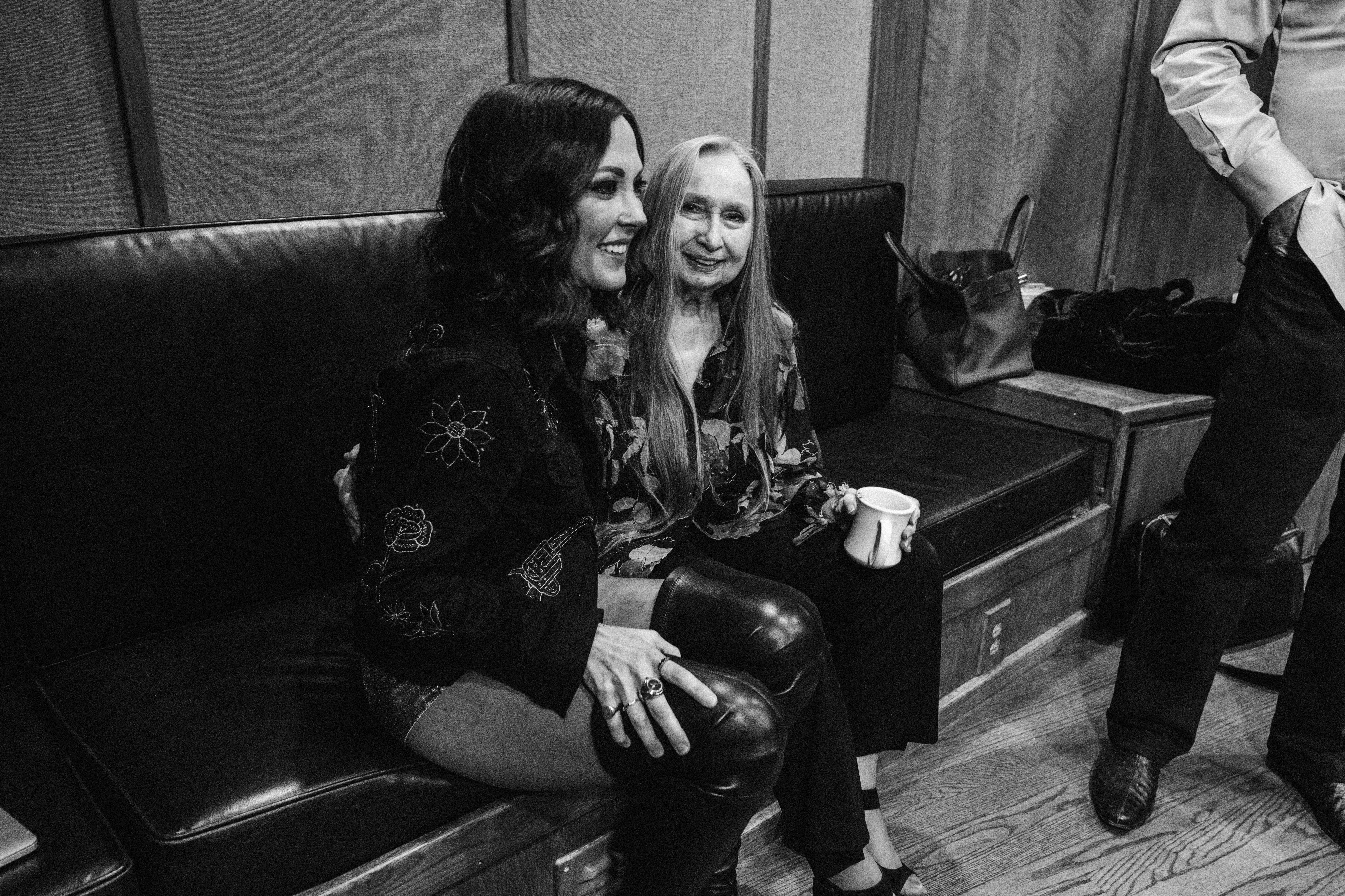 Amanda Shires and Bobbie Nelson are seated on a couch in a recording studio