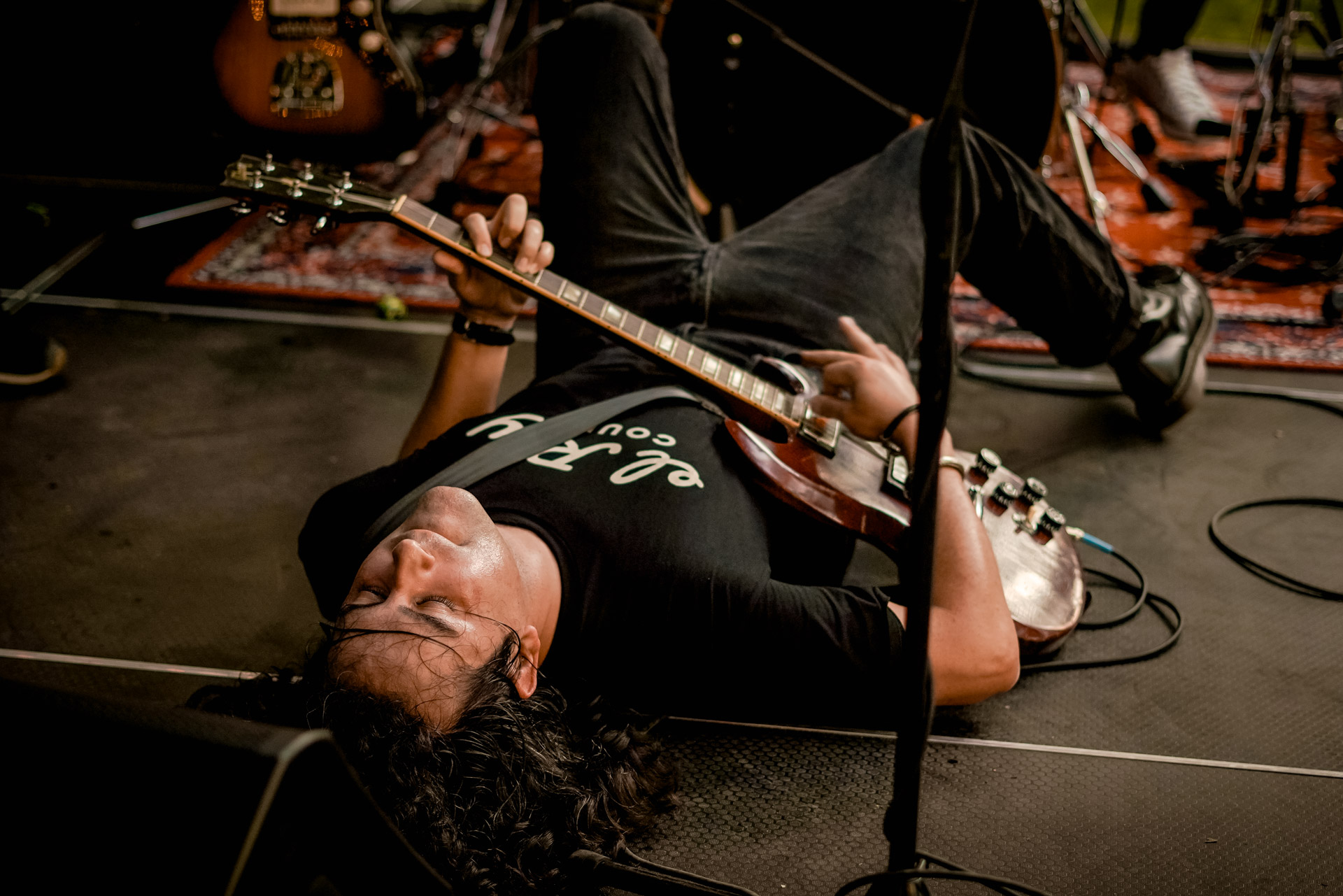 A musician laying on stage playing guitar
