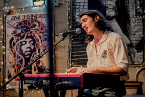 A musician playing keyboard and singing