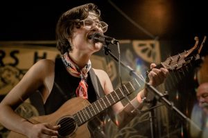 A musician playing guitar and singing