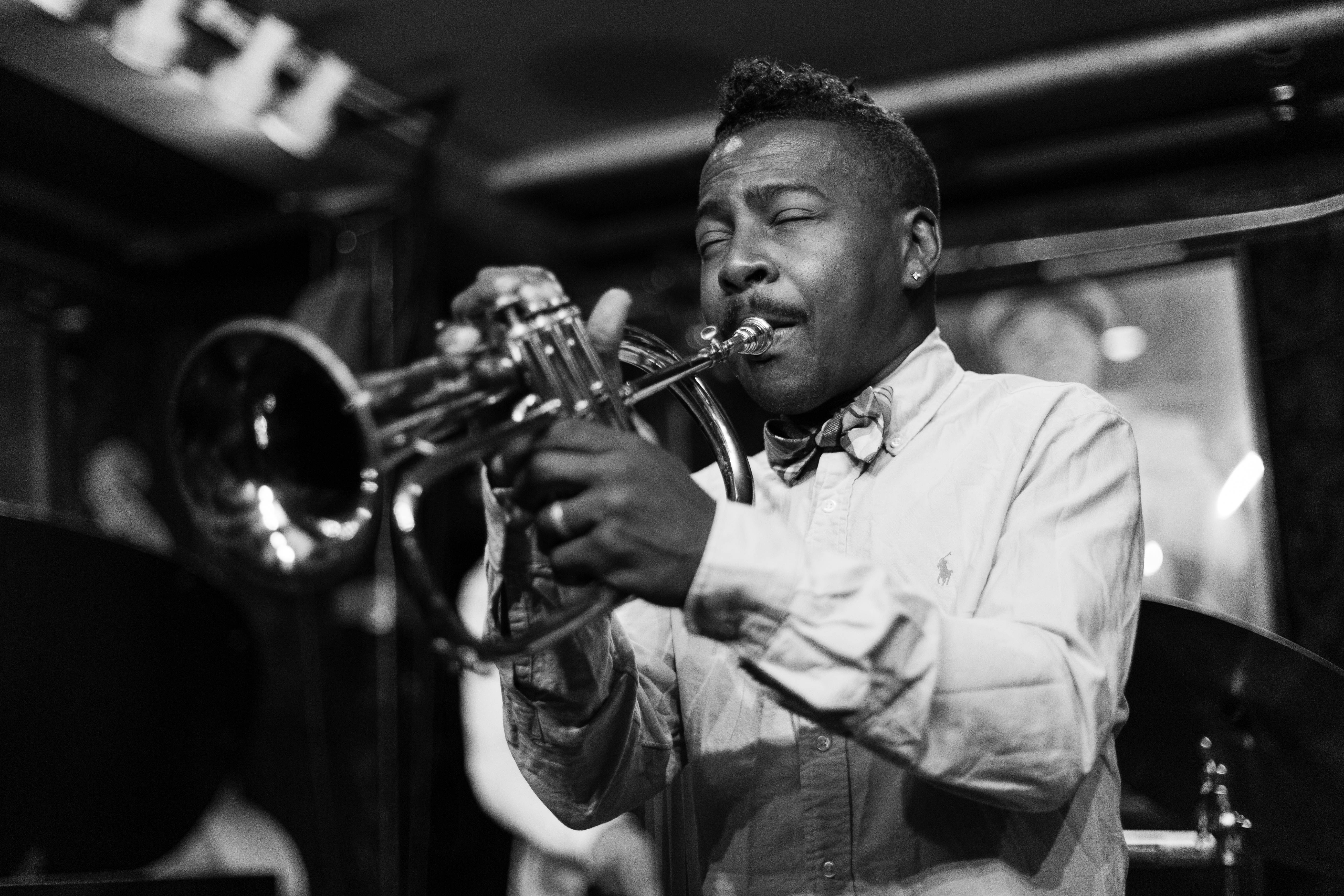 Roy Hargrove, wearing a shirt and bow tie, plays the trumpet