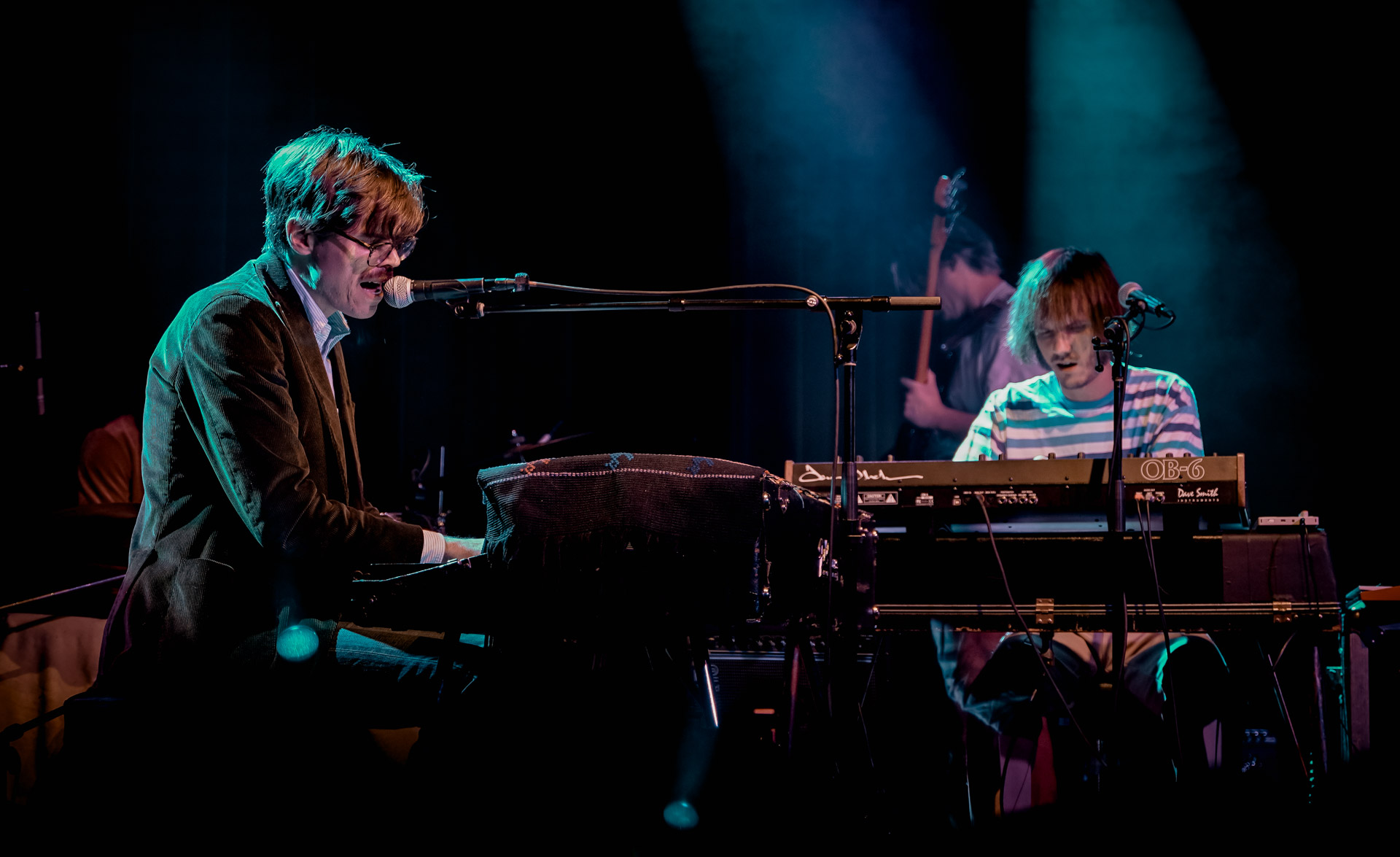 Two musicians playing keyboard on stage