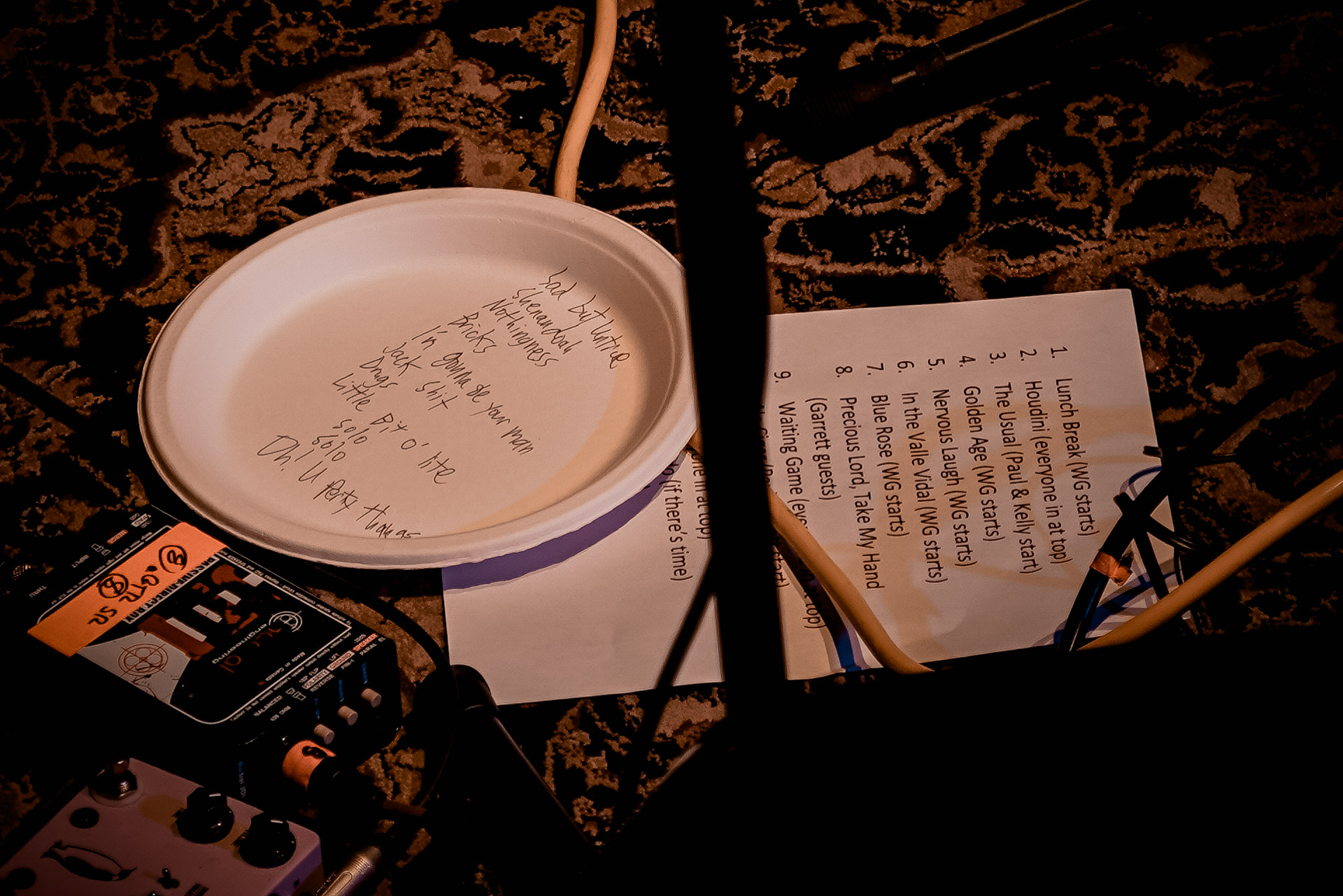 Set lists on stage, one written on a paper plate, one typed on a piece of paper