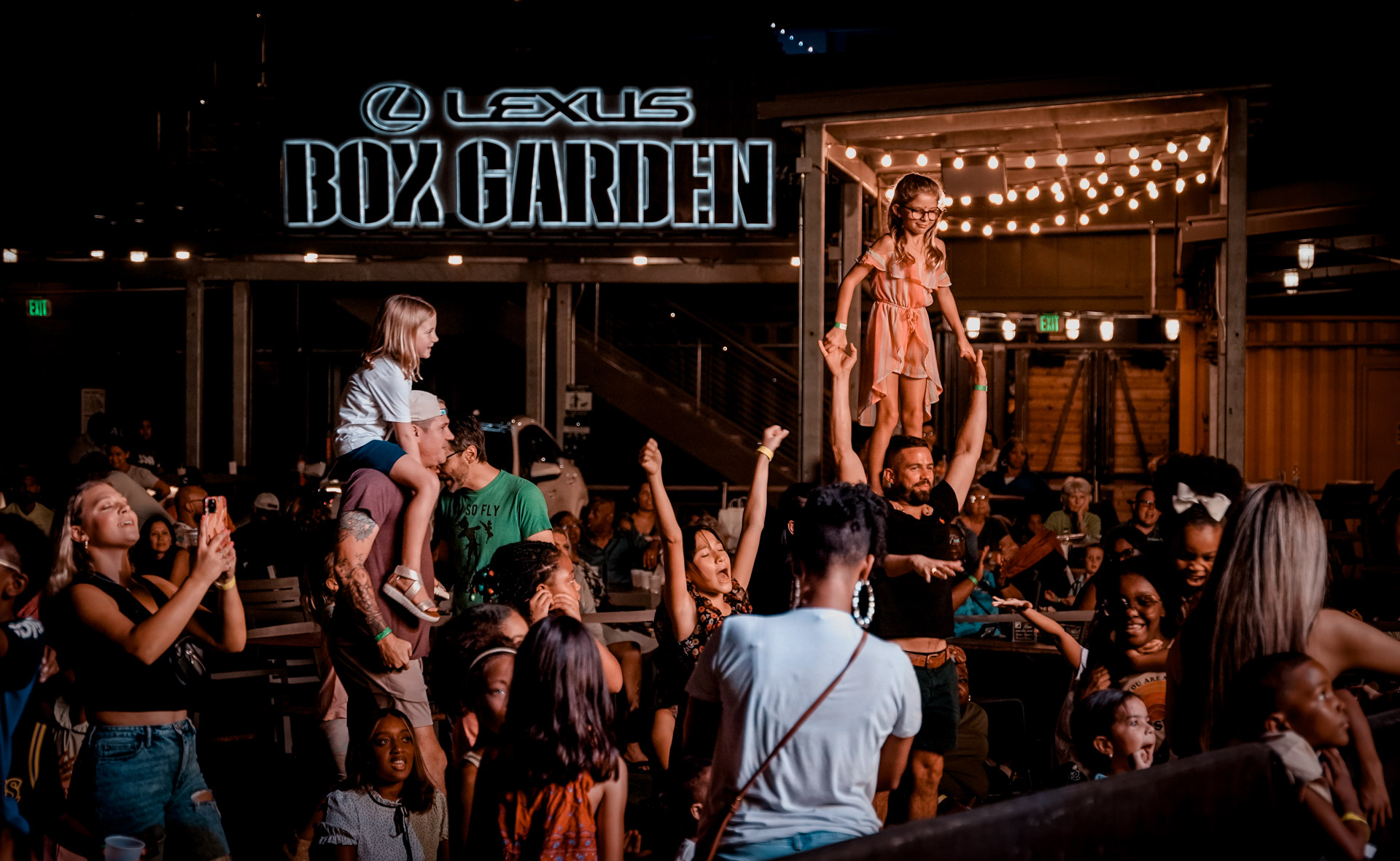 A crowd of people with kids on adults' shoulders