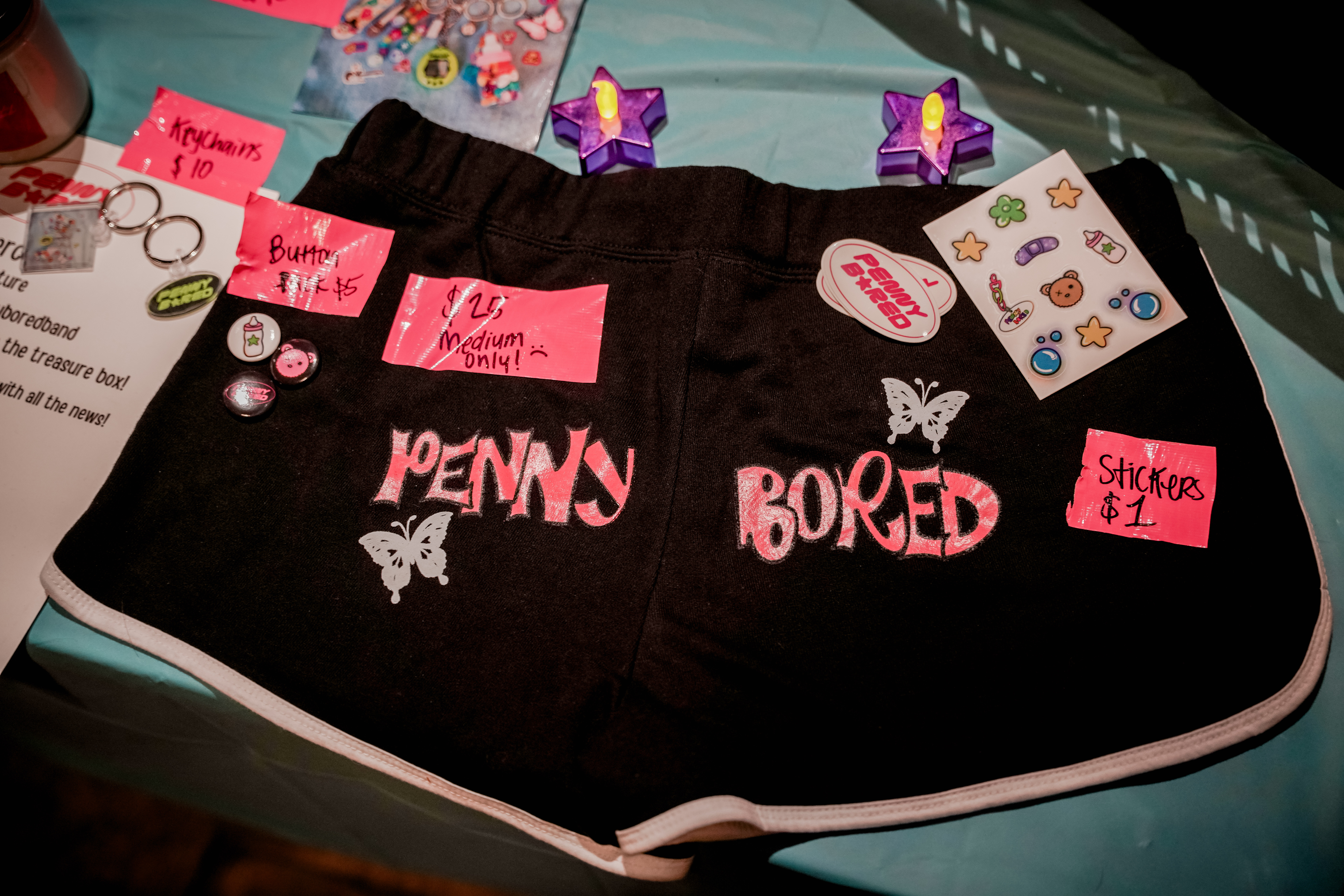 A merch table with stickers and shorts