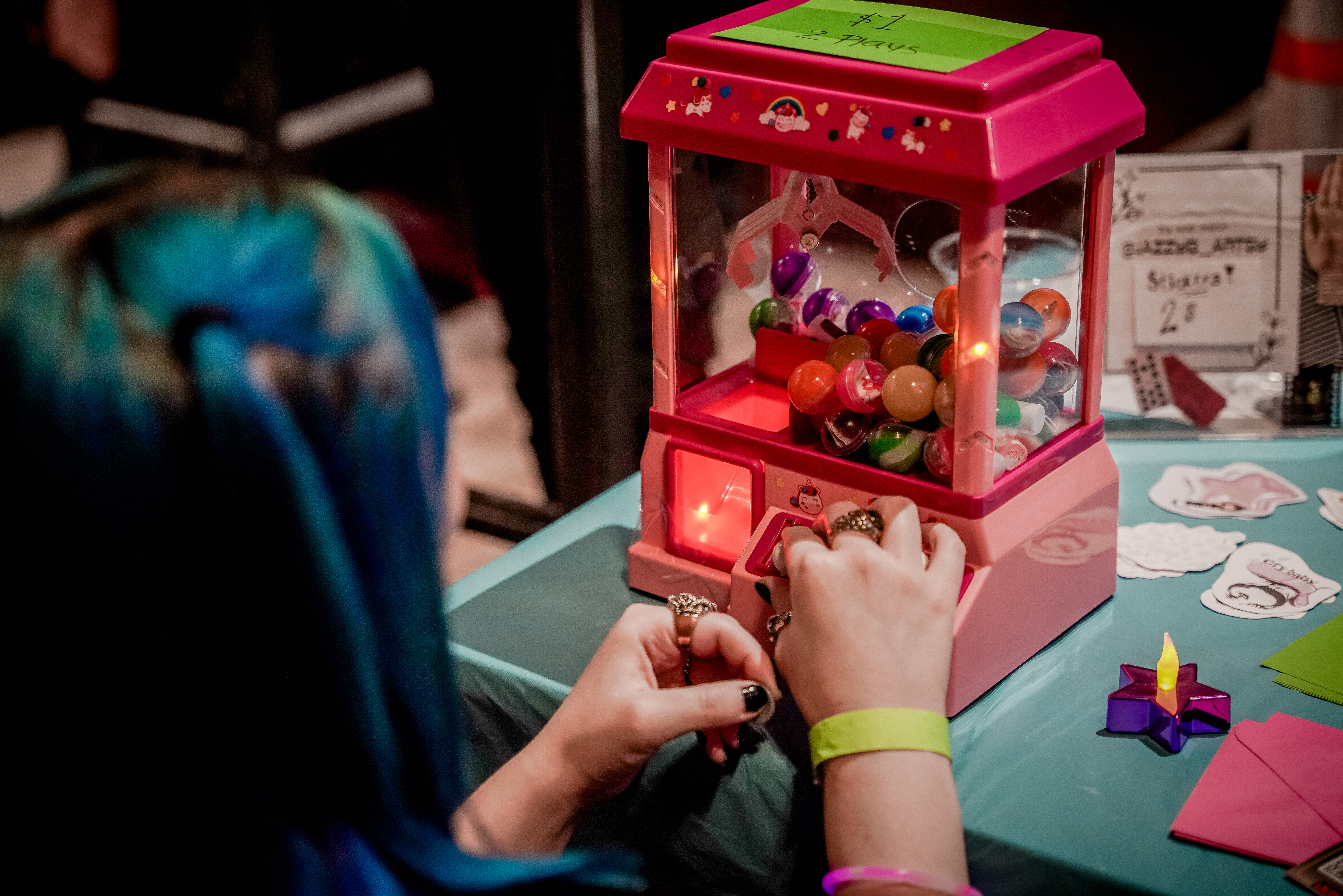 A person playing a claw game with bouncy balls