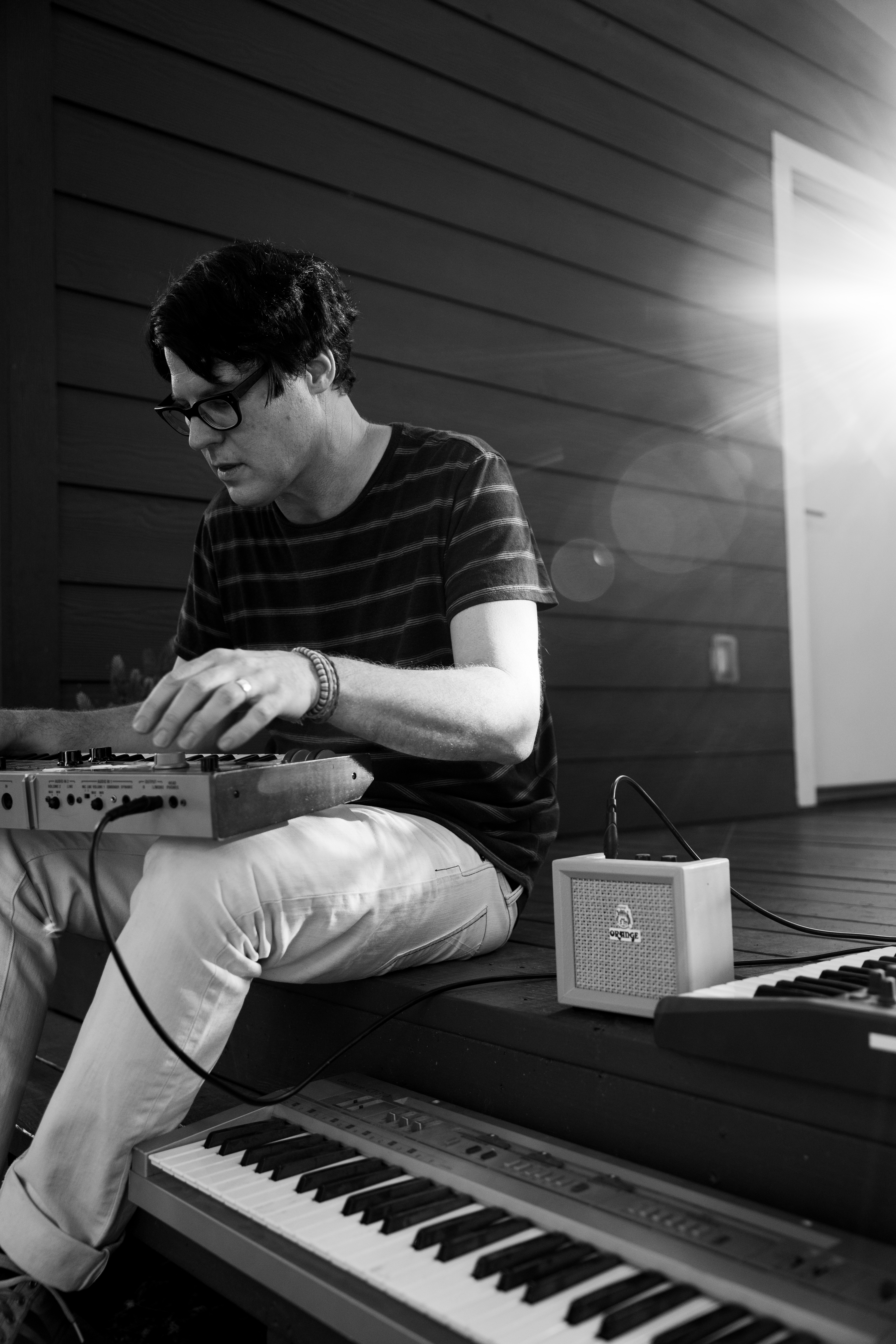Playing with instruments, John Dufilho sits on a step