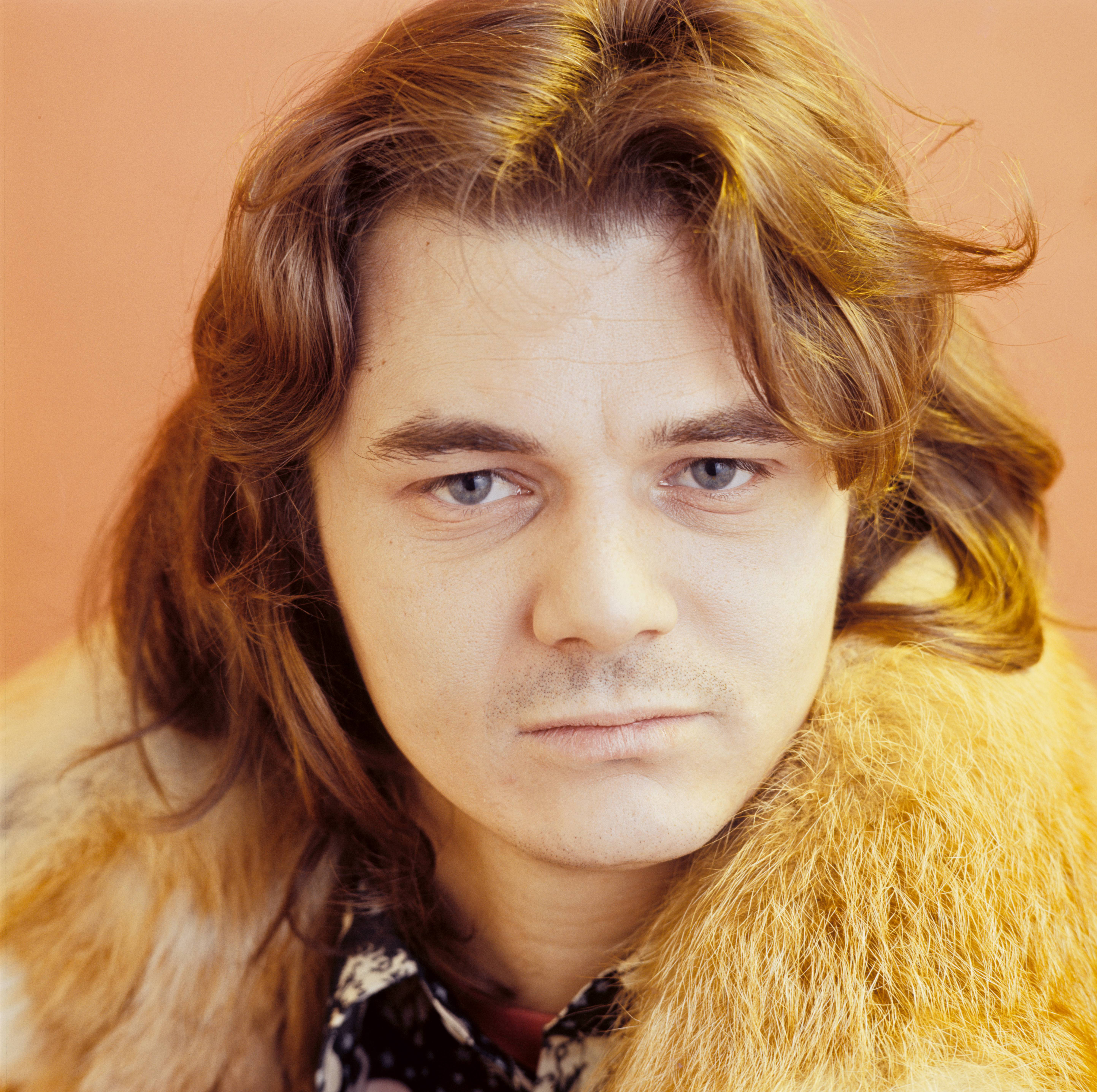 Steve Miller, wearing a feathery yellow coat, poses for a photo