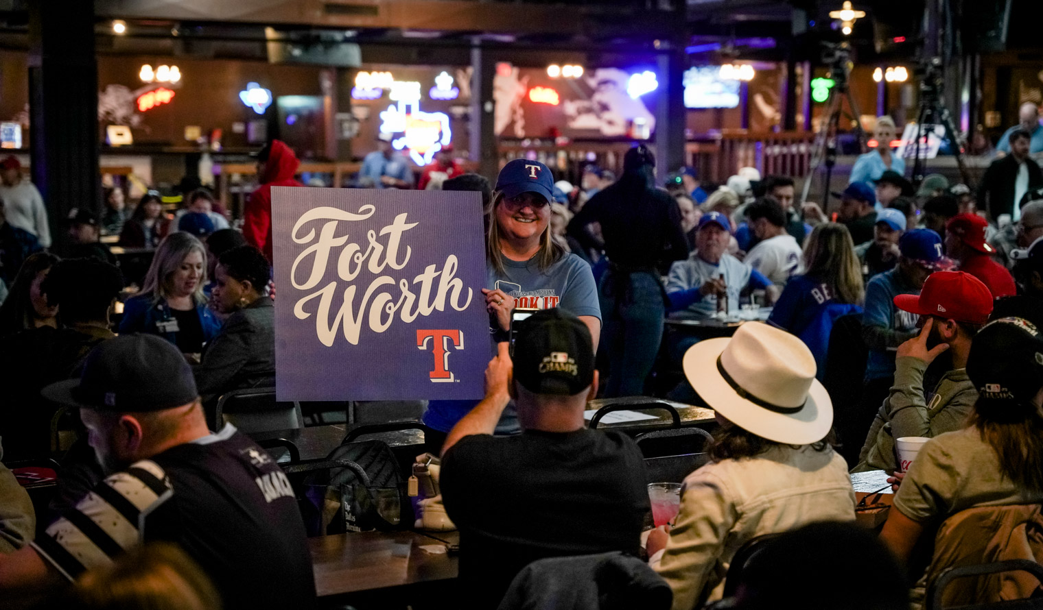 A woman posing with a sign that says "Fort Worth"