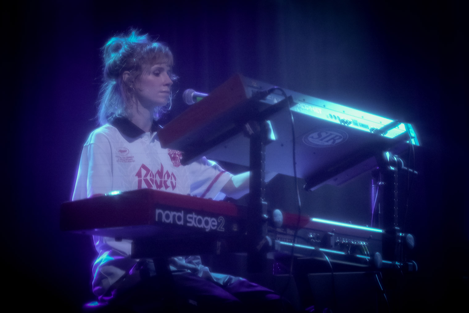 A musician on stage playing keyboards