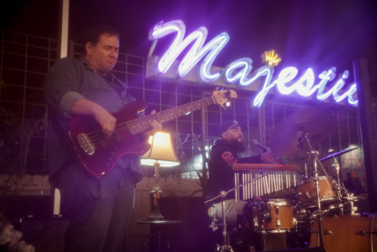 A band on stage in front of a neon sign