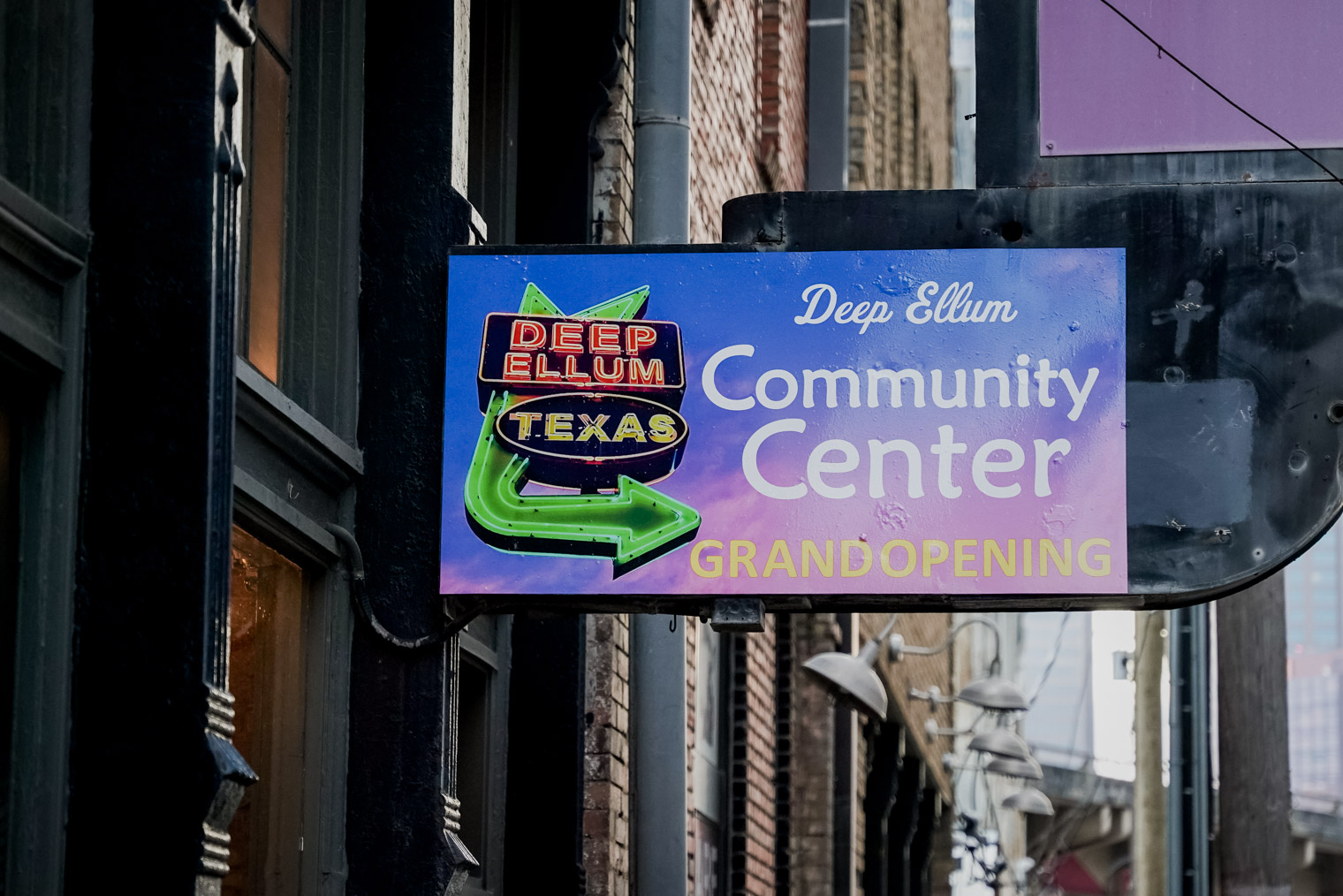 A sign that says "Deep Ellum Community Center Grand Opening"