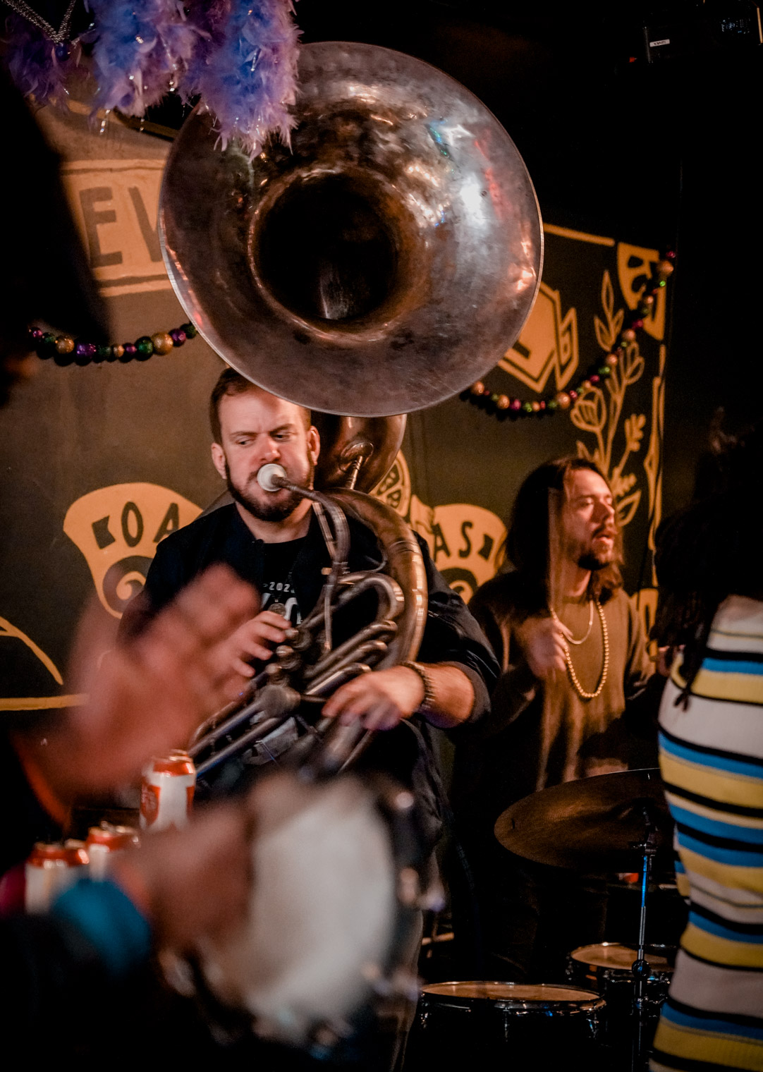 Musicians playing sousaphone, drums, tambourine 