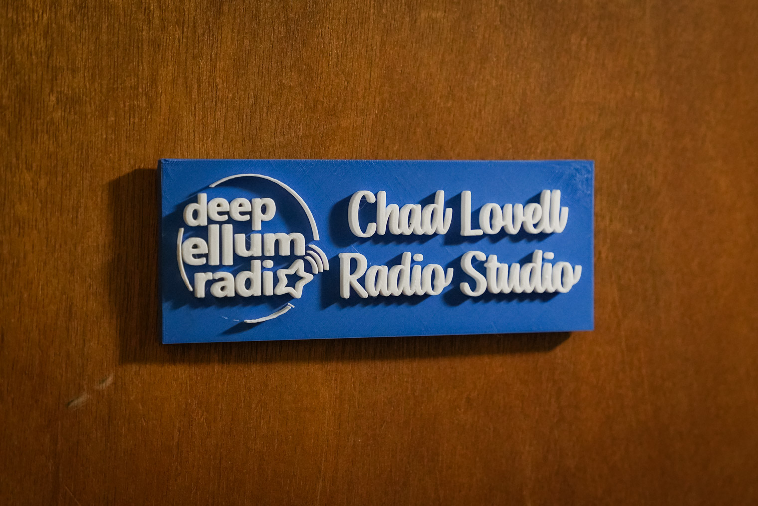 A sign on a door that says "deep ellum radio, Chad Lovell Radio Studio"