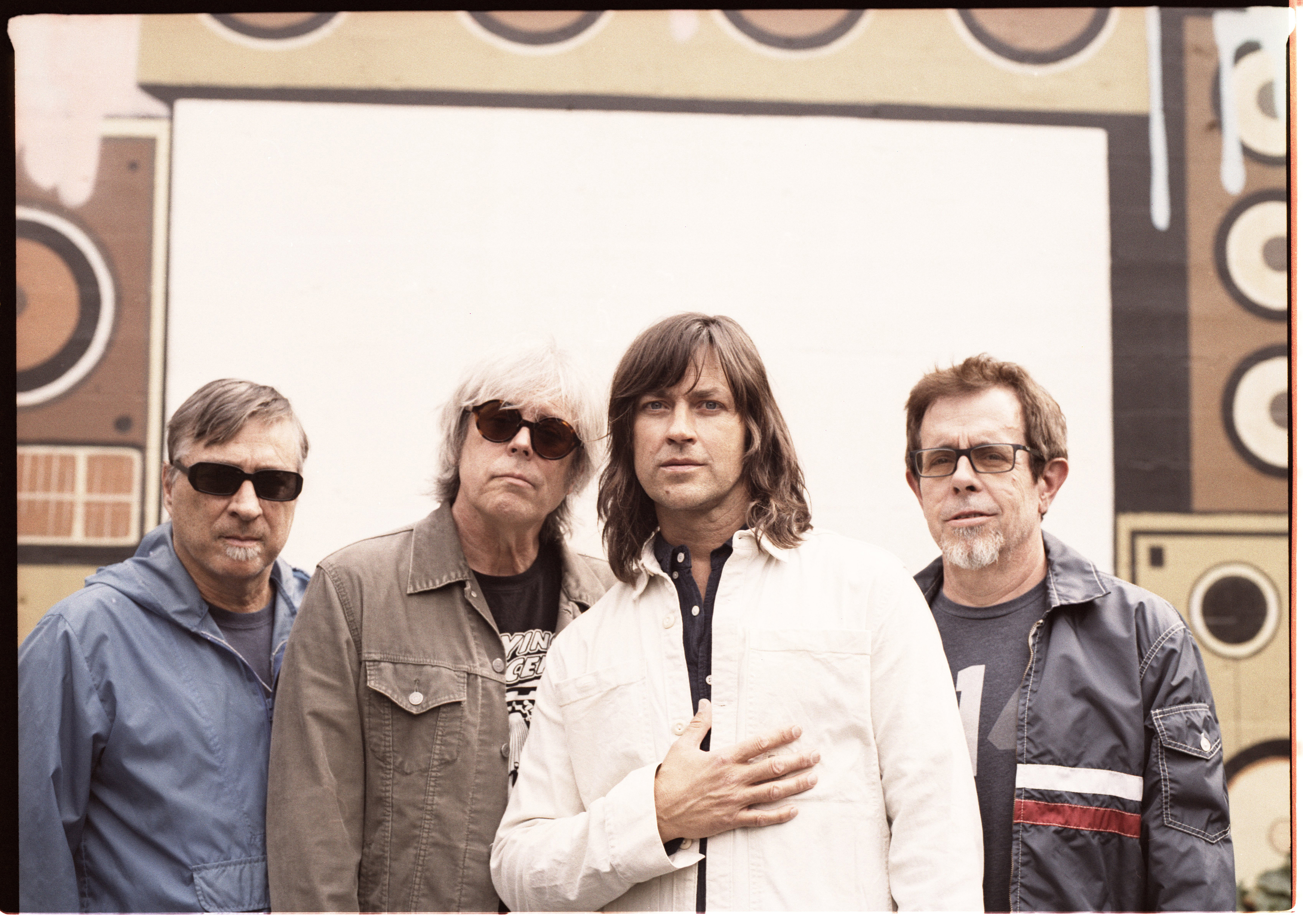 Standing in front of a painted wall, the Old 97s face the camera