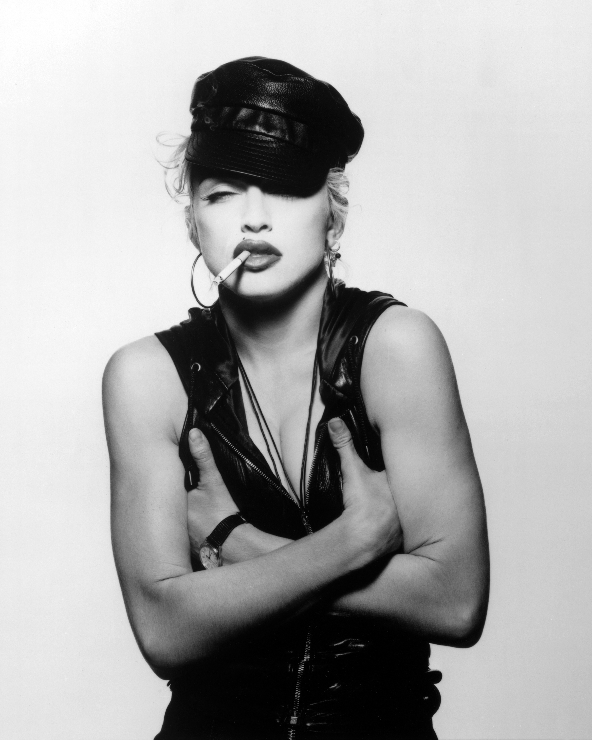 Wearing a cap with a cigarette in her mouth, Madonna crosses her arms for the camera