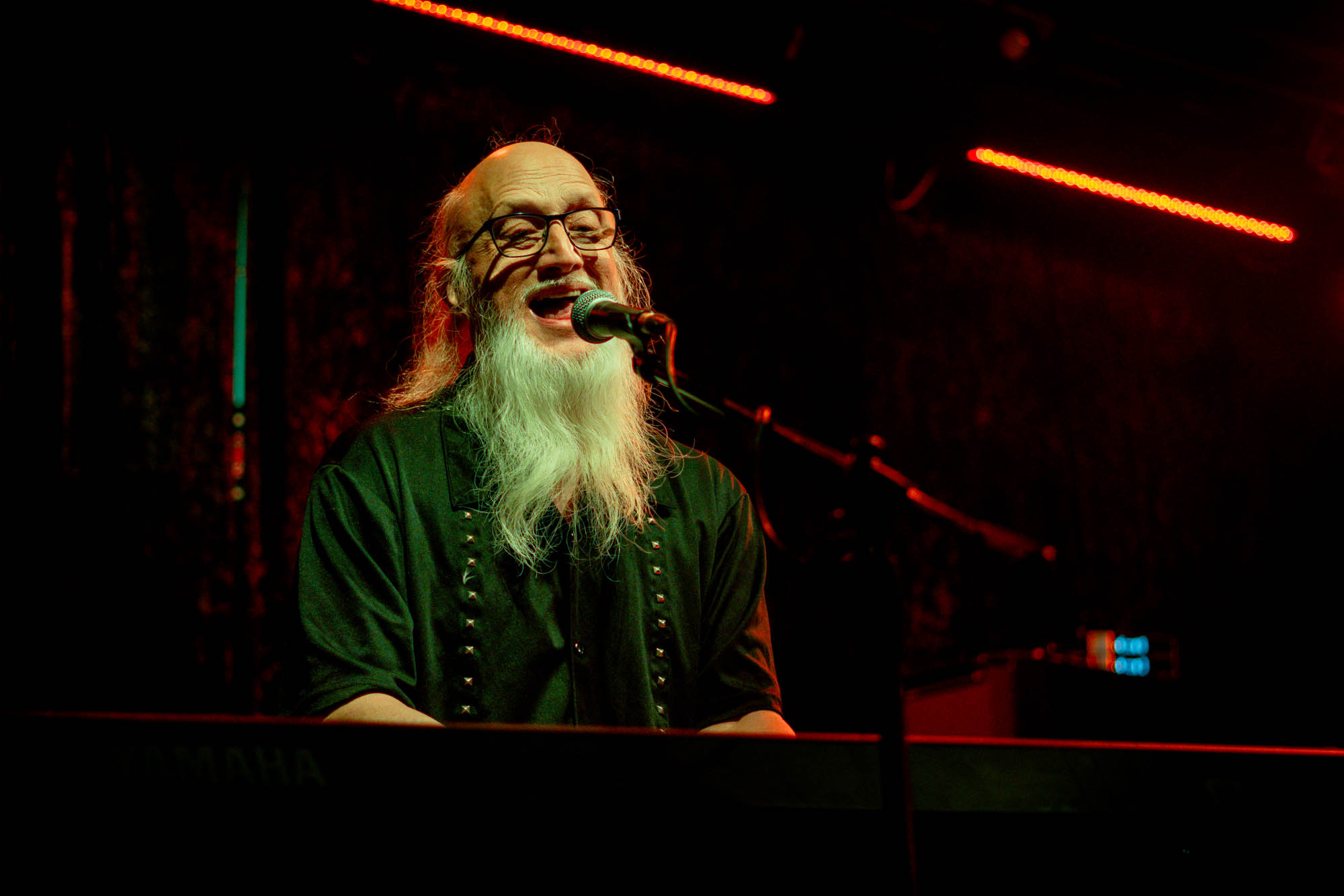 A musician playing keyboard on stage and singing
