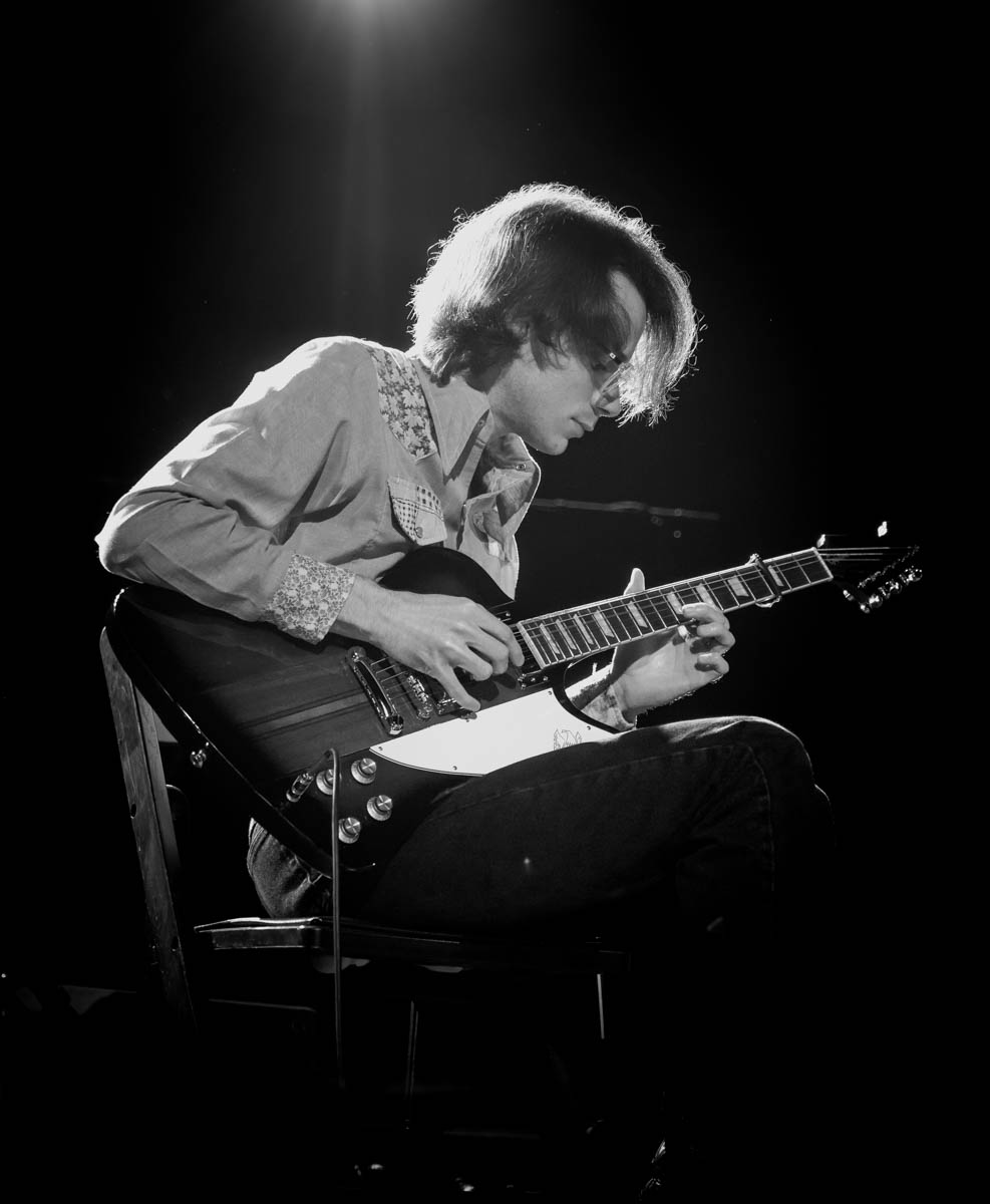 A musician plays guitar on stage