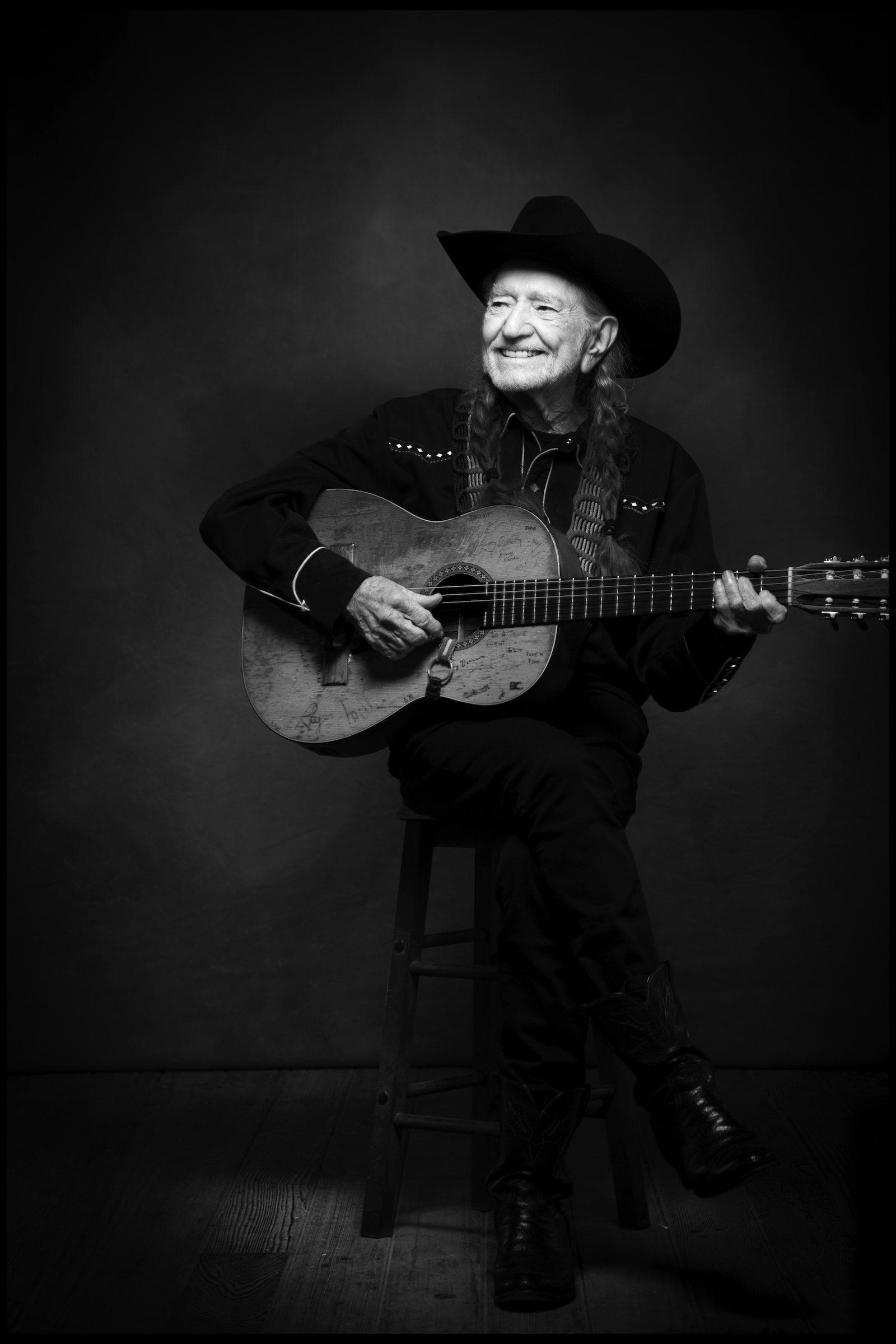 Willie Nelson, holding Trigger, smiles for the camera