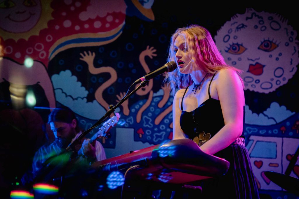 A musician on stage playing keyboard and singing