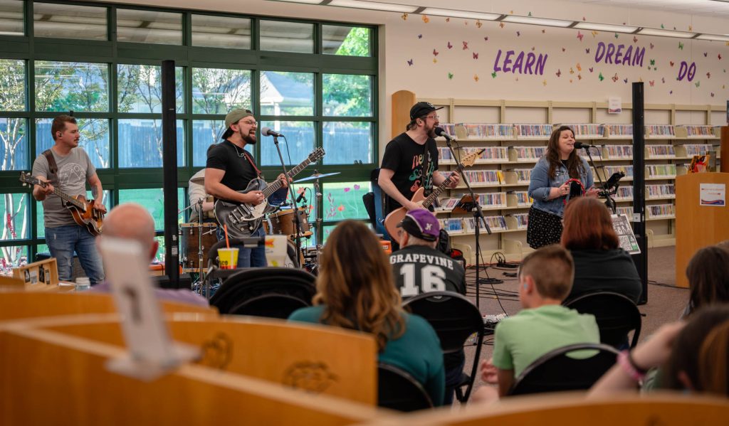 A full band playing music inside a library