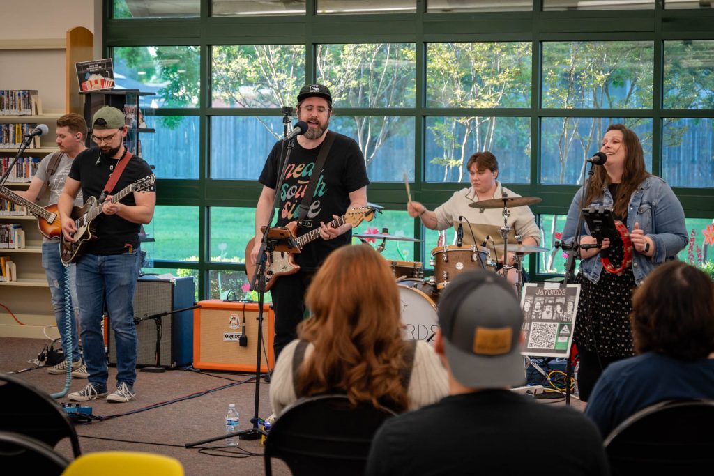 A full band playing in a library